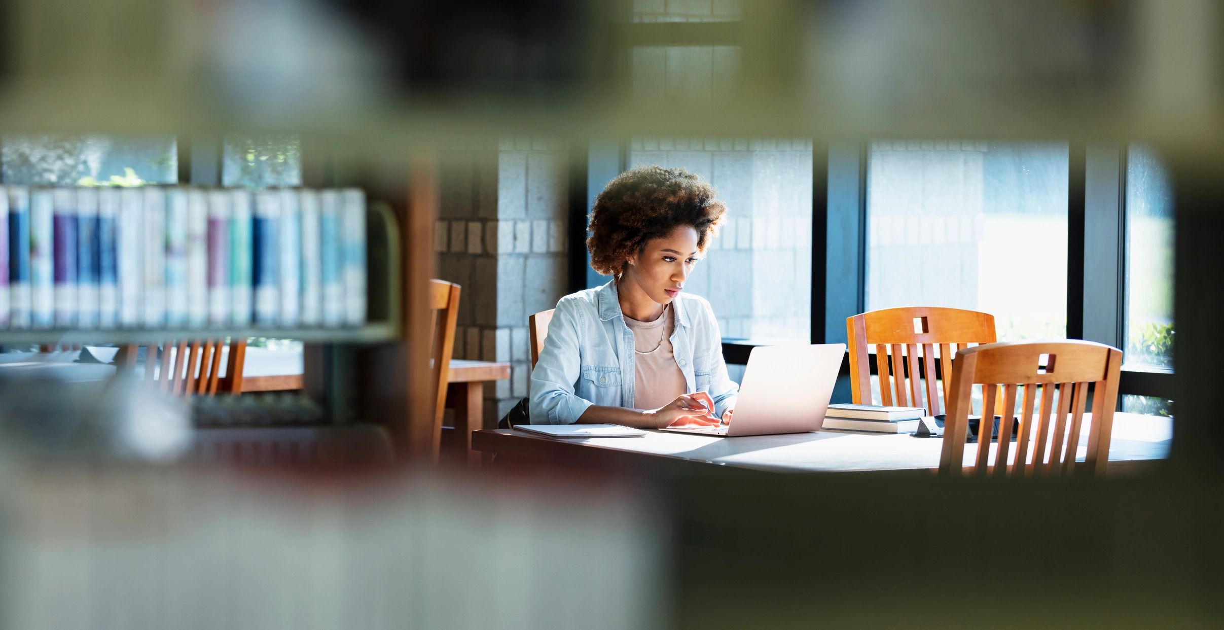 Young woman studying with laptop—focused and hopeful